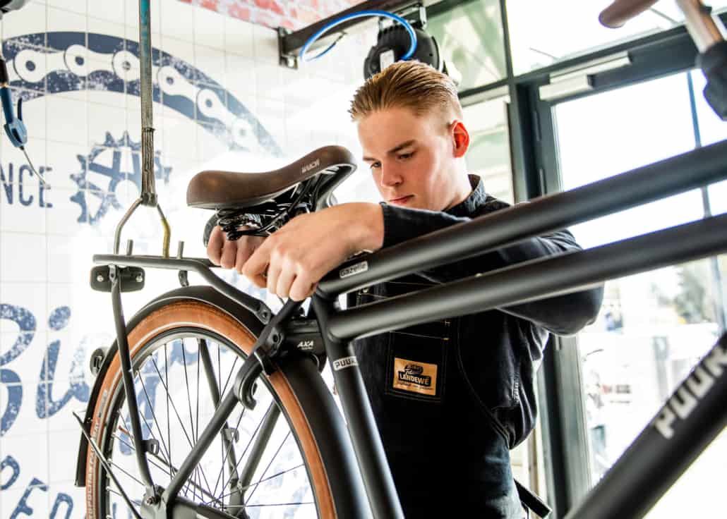 Een monteur werkt aan een fiets in de werkplaats